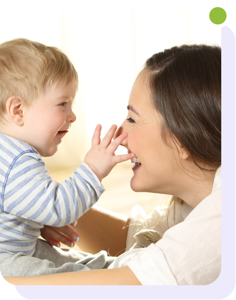 A smiling young woman and a laughing baby touching noses