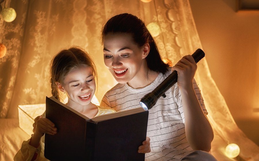 A babysitter reading a bedtime story with a child